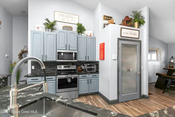 a kitchen with stainless steel appliances granite countertop a stove a refrigerator and a sink