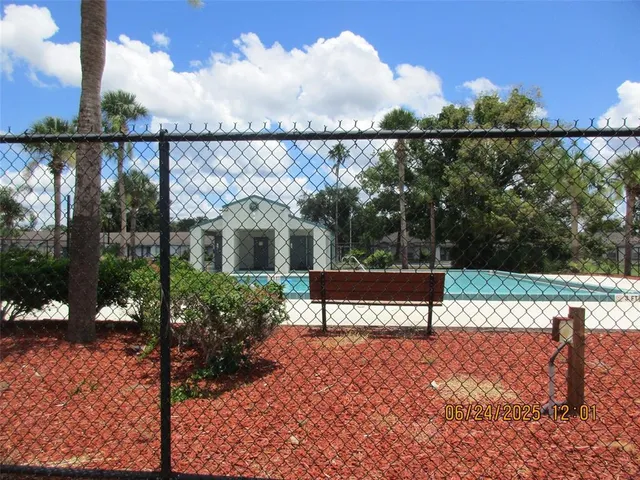 a view of a house with a yard potted plants and a large tree