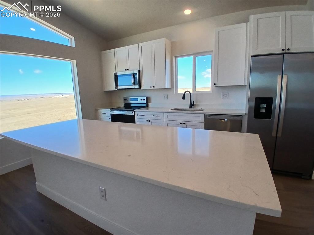 19981 Cloudfield Point Colorado Springs, CO 80928 - Photo 11 of 42 a kitchen with stainless steel appliances a refrigerator sink and white cabinets