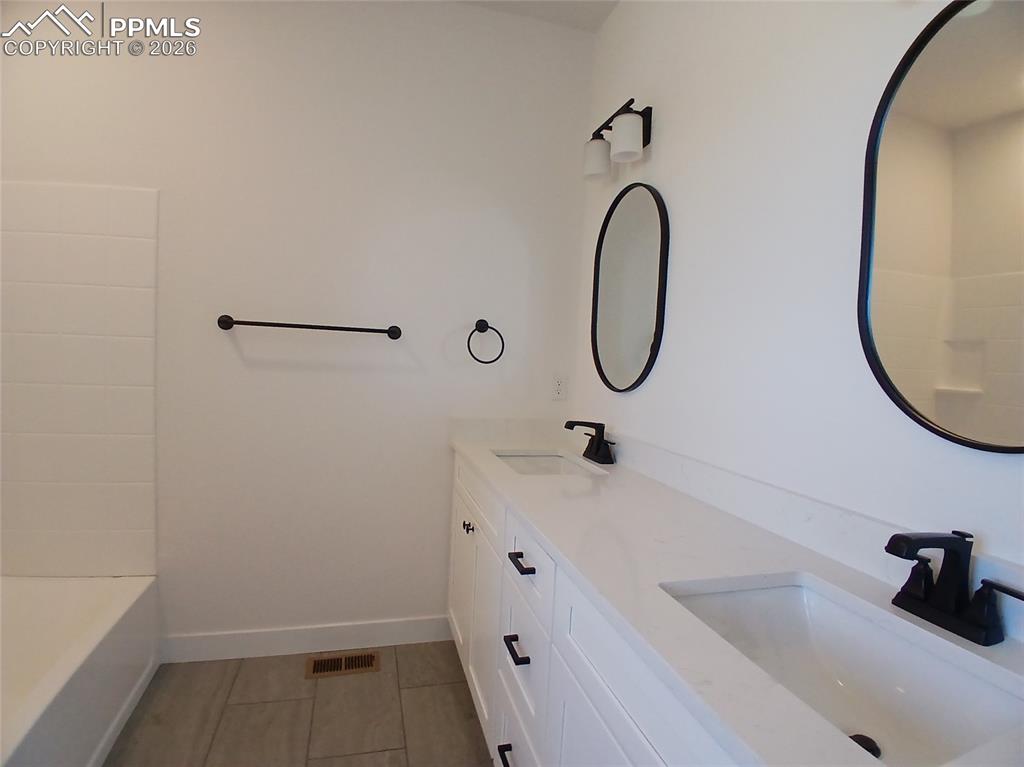 19981 Cloudfield Point Colorado Springs, CO 80928 - Photo 18 of 42 a bathroom with a tub sink and mirror