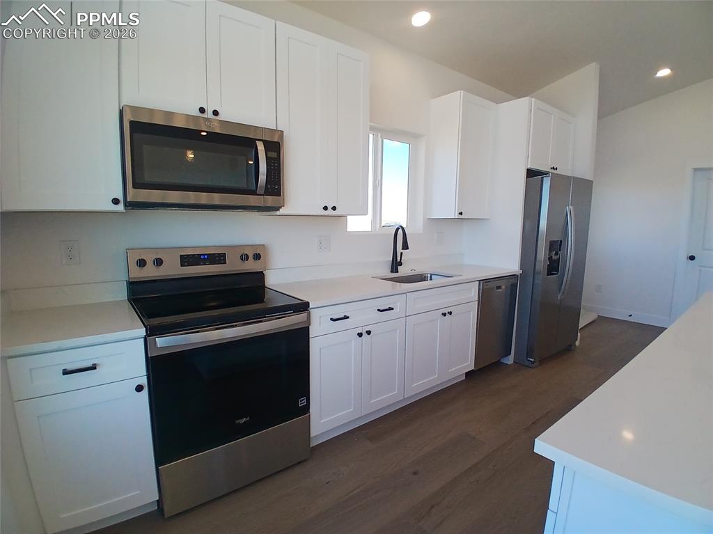 19981 Cloudfield Point Colorado Springs, CO 80928 - Photo 21 of 42 a kitchen with stainless steel appliances a stove microwave and sink