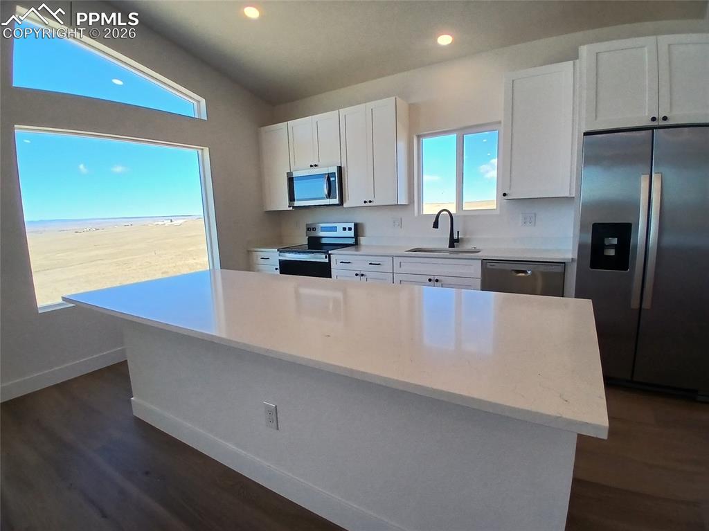 19981 Cloudfield Point Colorado Springs, CO 80928 - Photo 4 of 42 a kitchen with stainless steel appliances a refrigerator a sink a stove a counter space and wooden floor
