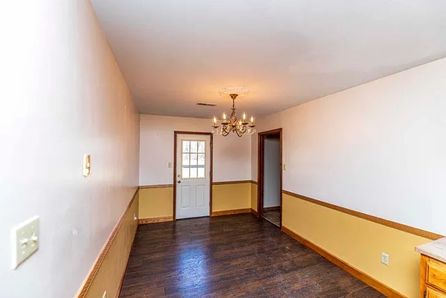 a view of a room with wooden floor fireplace and window