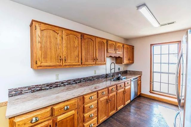 a kitchen with stainless steel appliances granite countertop a stove a sink and a microwave