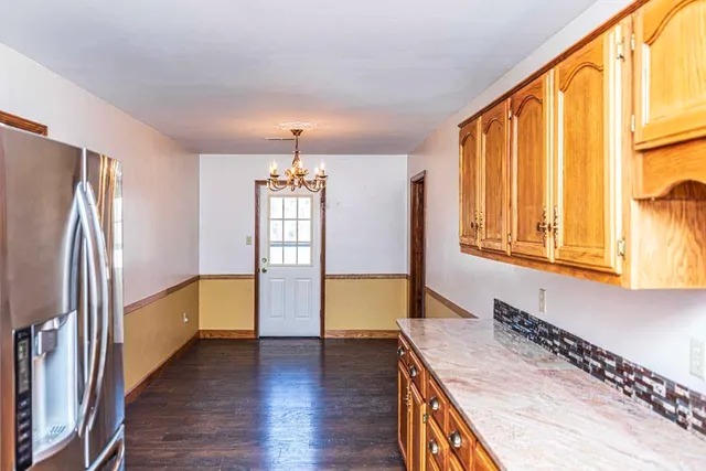 a kitchen with stainless steel appliances granite countertop a refrigerator a sink and wooden cabinets