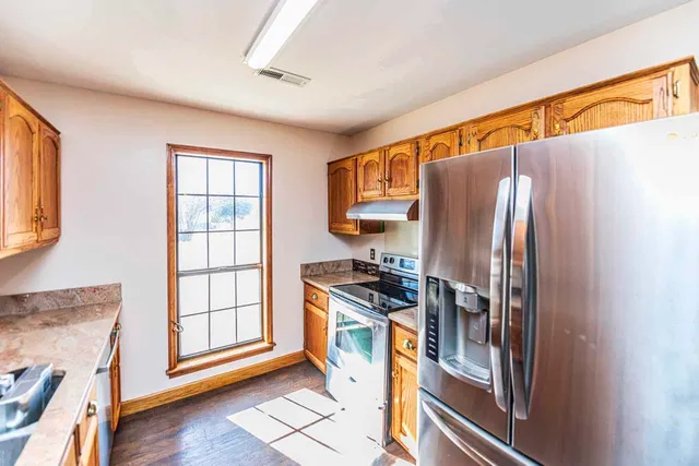 a kitchen with stainless steel appliances granite countertop a refrigerator and a stove