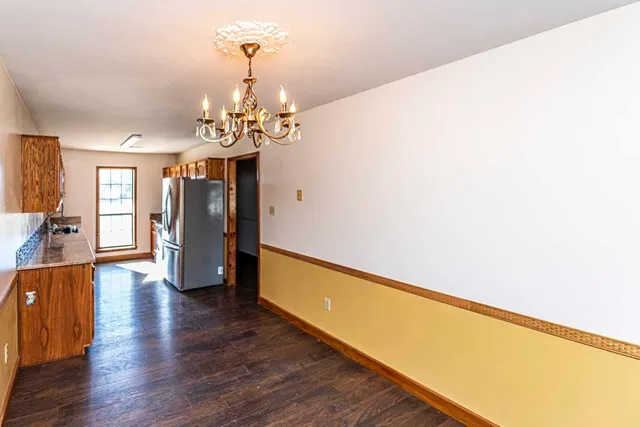 a view of a kitchen with wooden floor and stainless steel appliances