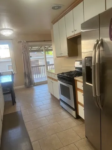 a kitchen with stainless steel appliances granite countertop a stove a sink and a refrigerator