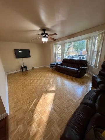 a living room with furniture and a ceiling fan