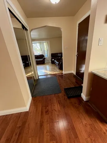 a living room with wooden floor and a rug