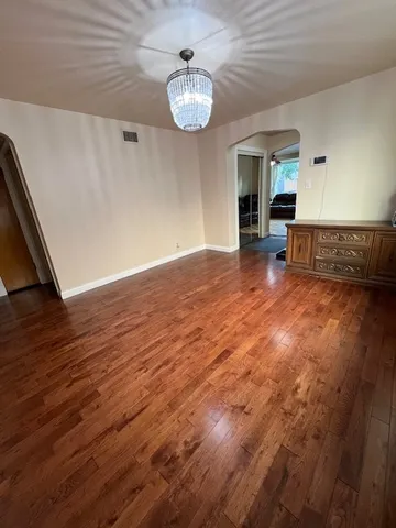 a view of a livingroom with wooden floor and a ceiling fan
