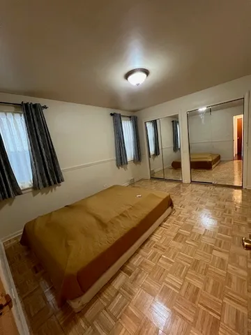 a bed sitting in a room and kitchen view