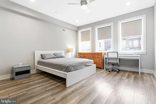 a spacious bedroom with a bed and a table chair