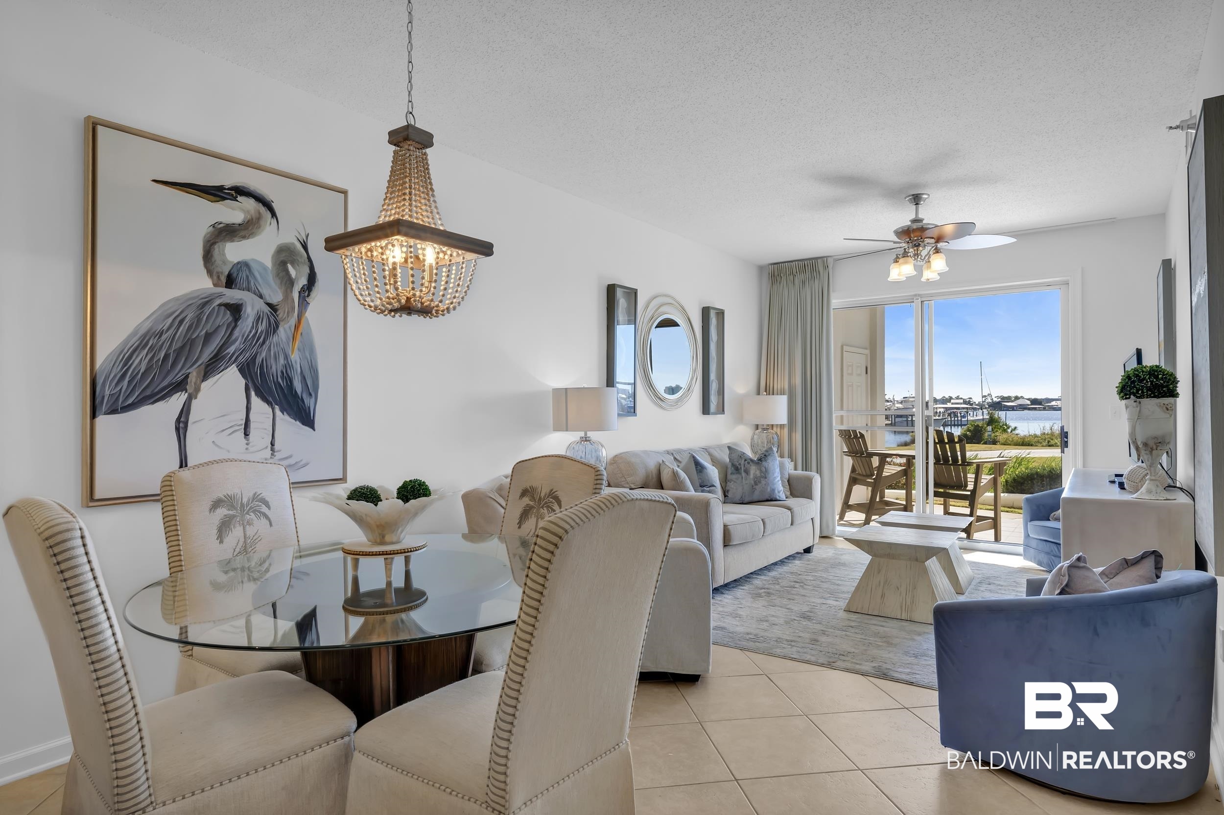 27282 Canal Road, Unit 104 Orange Beach, AL 36561 - Photo 10 of 79 Dining space featuring light tile patterned floors, a textured ceiling, a chandelier, ceiling fan, and a water view