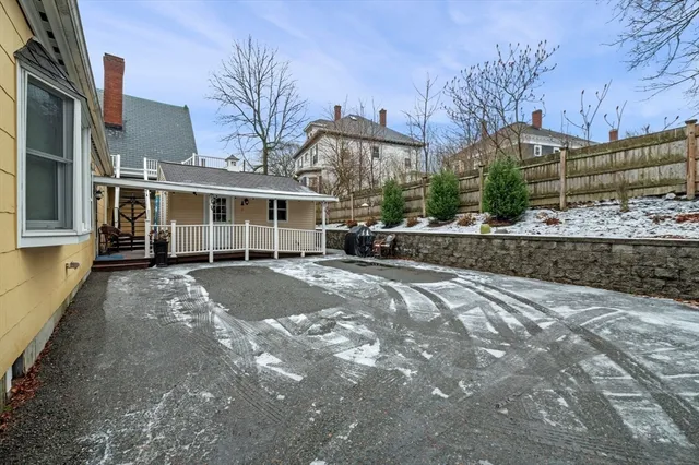 a view of a white house with a yard covered in snow