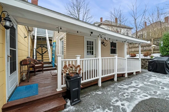 a view of a house with a wooden deck and furniture