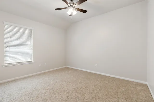 an empty room with a window and a fan