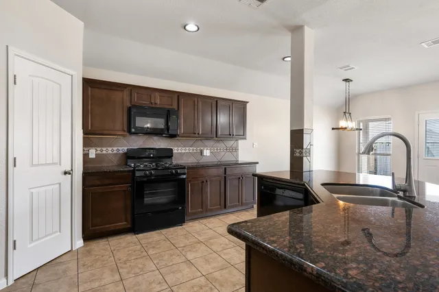 a kitchen with a stove sink and refrigerator