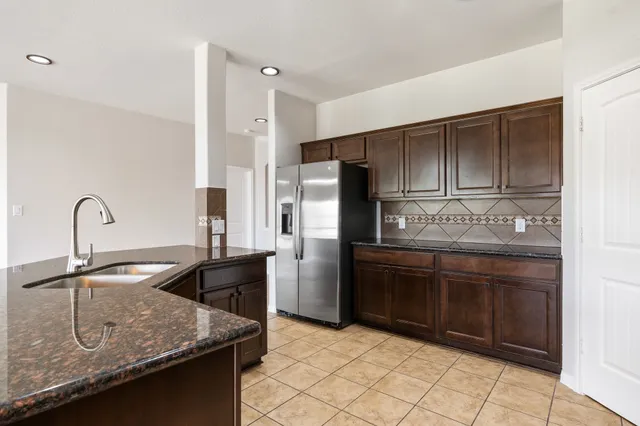 a kitchen with granite countertop a sink stainless steel appliances and cabinets