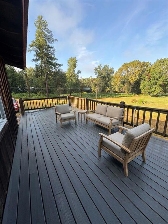 175 Marie Road Ringgold, LA 71068 - Photo 15 of 20 Expansive outdoor deck featuring dark-toned composite decking, wood railing, and a verdant backdrop of mature trees