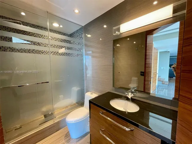 a bathroom with a sink a large mirror and a shower