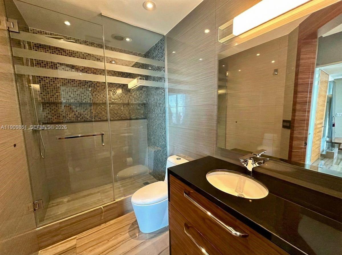 92 Southwest 3rd Street, Unit PH5213 Miami, FL 33130 - Photo 23 of 24 a bathroom with a sink shower and a mirror