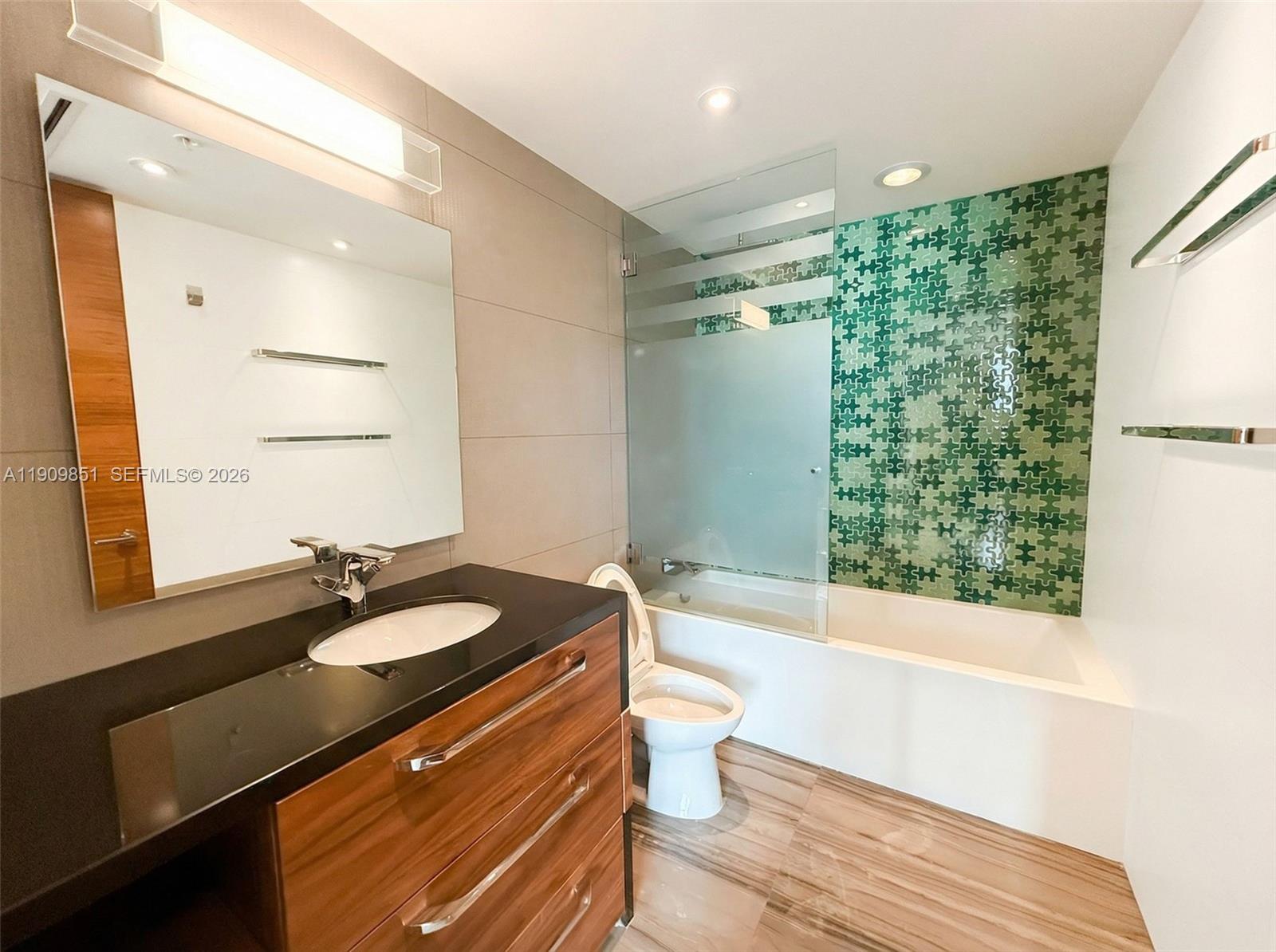 92 Southwest 3rd Street, Unit PH5213 Miami, FL 33130 - Photo 24 of 24 a bathroom with a sink a toilet a mirror and shower