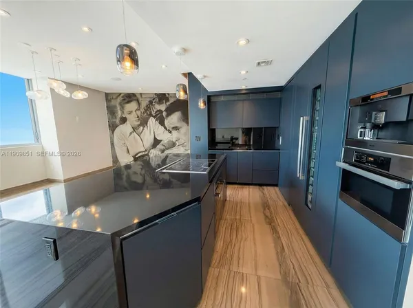 a kitchen with stainless steel appliances a sink stove and wooden floor