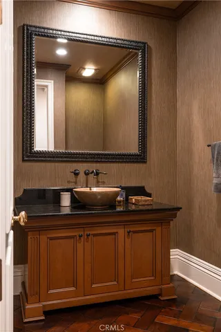 a bathroom with a sink a mirror and wooden cabinets