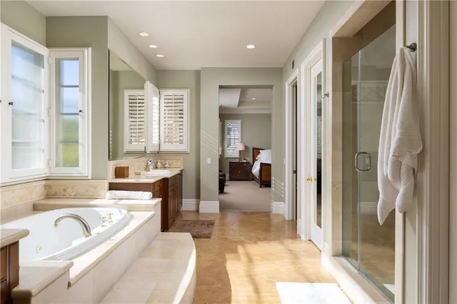 a spacious bathroom with a tub sink and mirror
