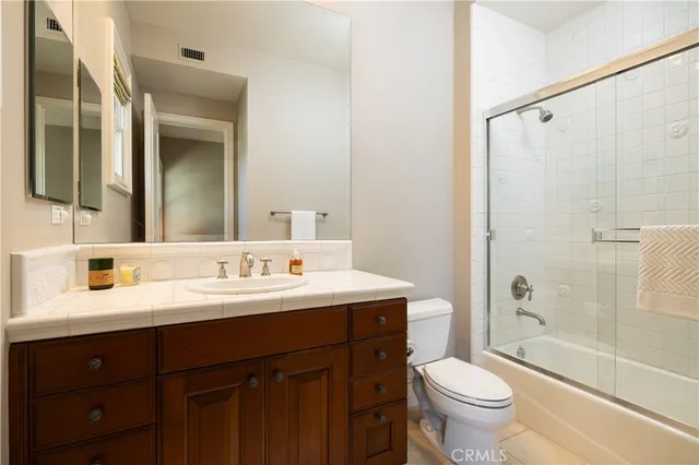 a bathroom with a double vanity sink toilet mirror and shower