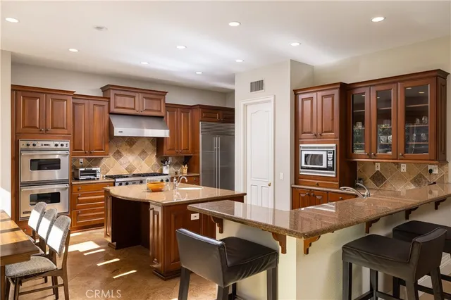 a kitchen with stainless steel appliances granite countertop a stove refrigerator and cabinets