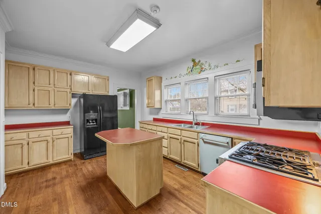 a kitchen with stainless steel appliances granite countertop a sink and a refrigerator