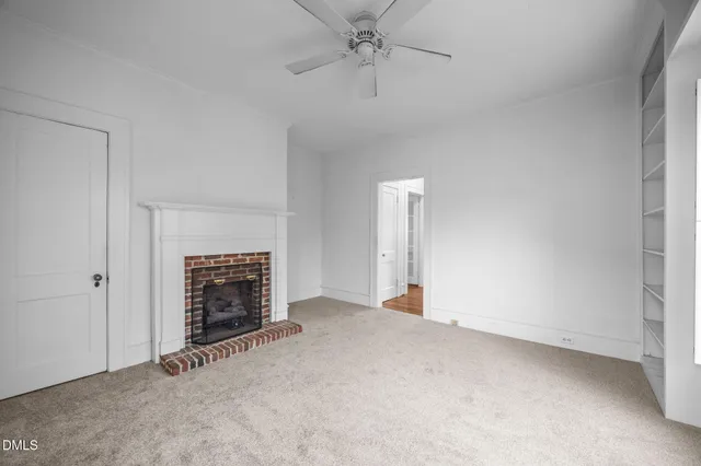 a view of empty room with windows and fireplace