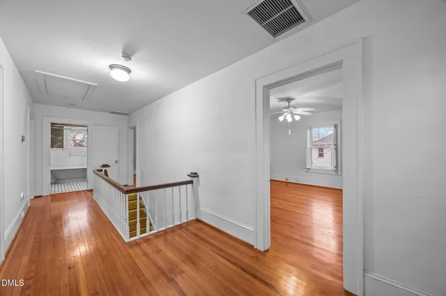 a view of a hallway with wooden floor and stairs