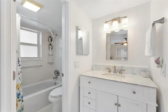 a bathroom with a sink a toilet a mirror a bathtub and shower