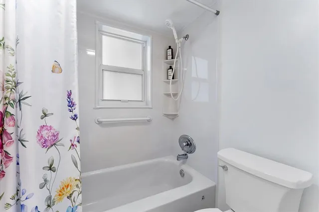 a white bath tub sitting next to a white toilet