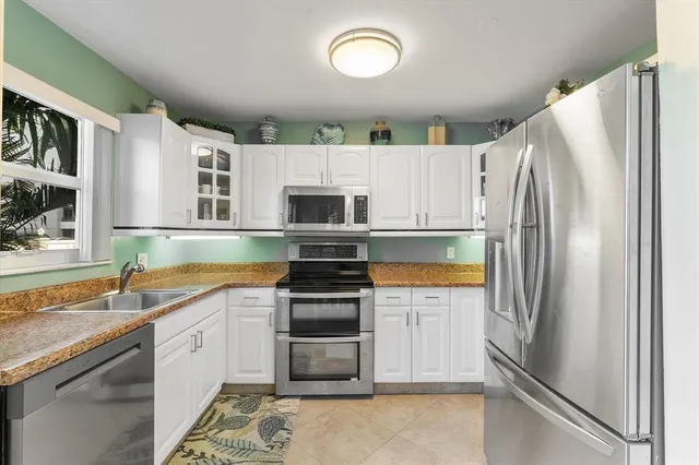 a kitchen with stainless steel appliances granite countertop a refrigerator sink and stove