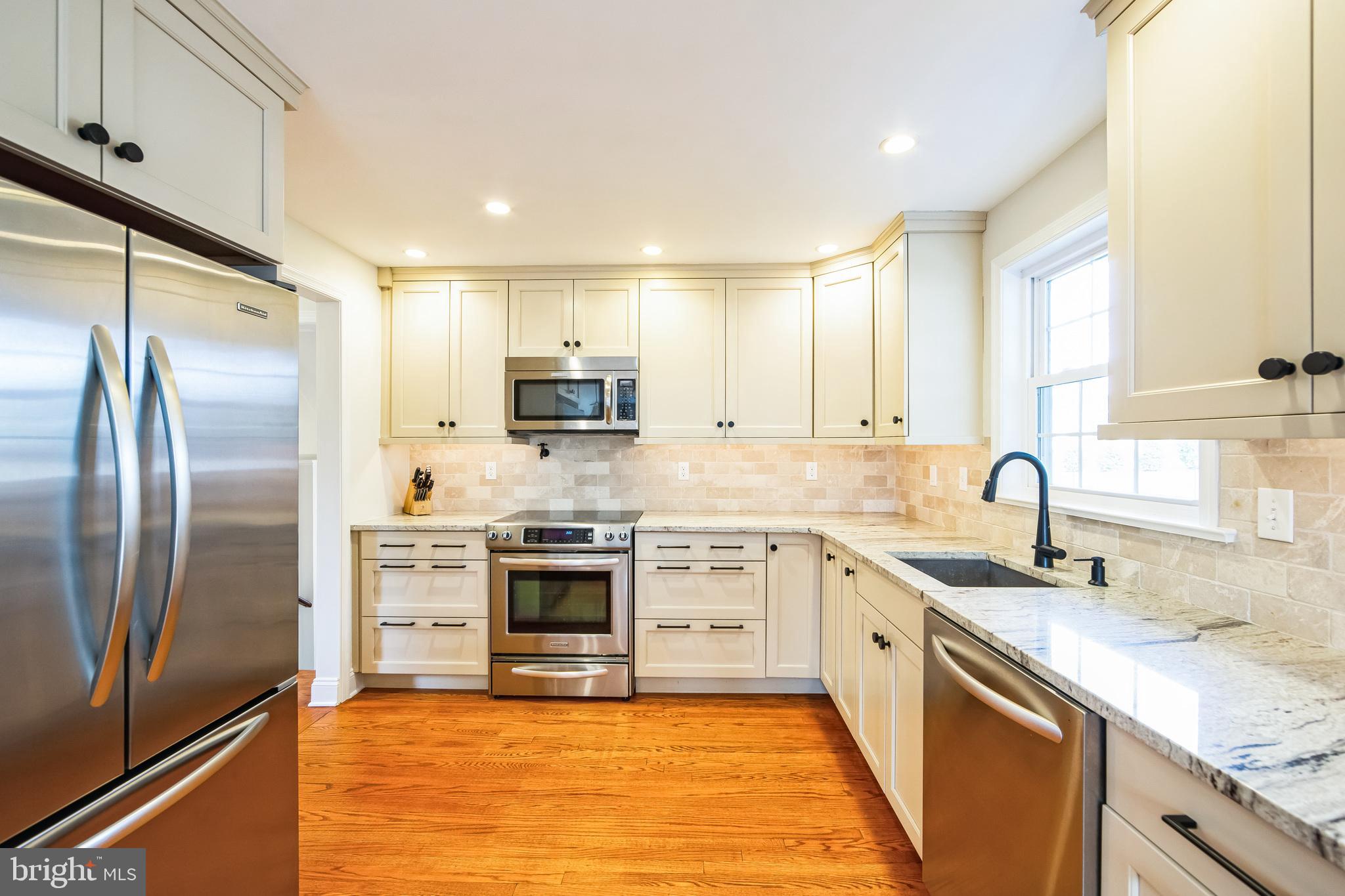 131 Clover Hill Lane Wayne, PA 19087 - Photo 10 of 50 a kitchen with stainless steel appliances granite countertop a sink stove refrigerator and cabinets