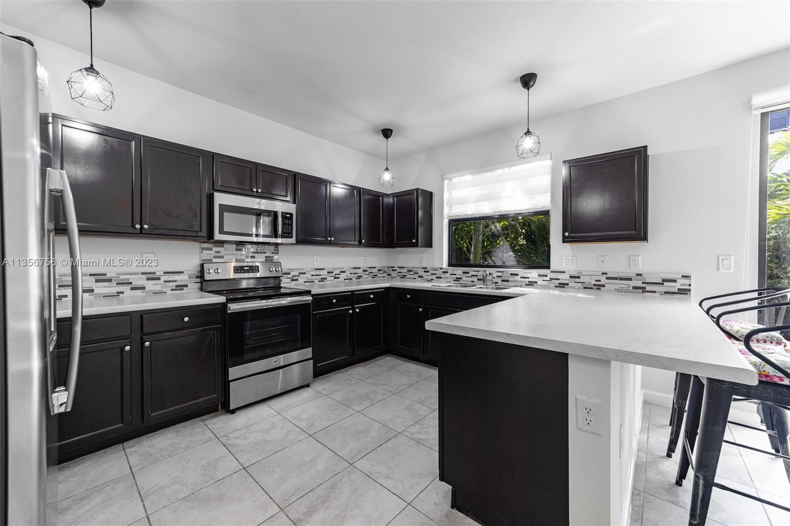 11444 Southwest 251st Street Homestead, FL 33032 - Photo 13 of 40 a kitchen with kitchen island granite countertop a sink appliances and cabinets