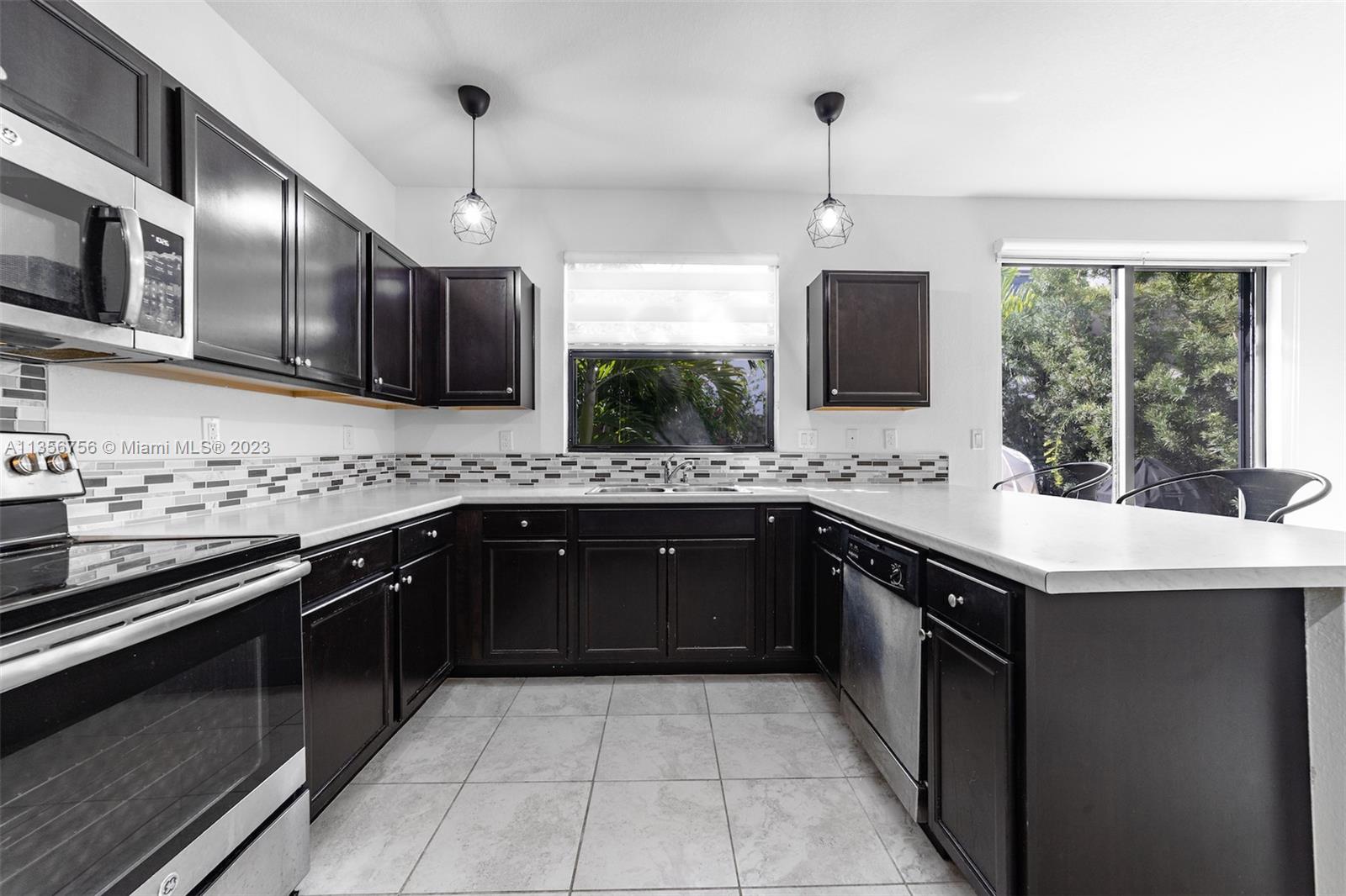 11444 Southwest 251st Street Homestead, FL 33032 - Photo 14 of 40 a kitchen with stainless steel appliances granite countertop a sink stove and cabinets