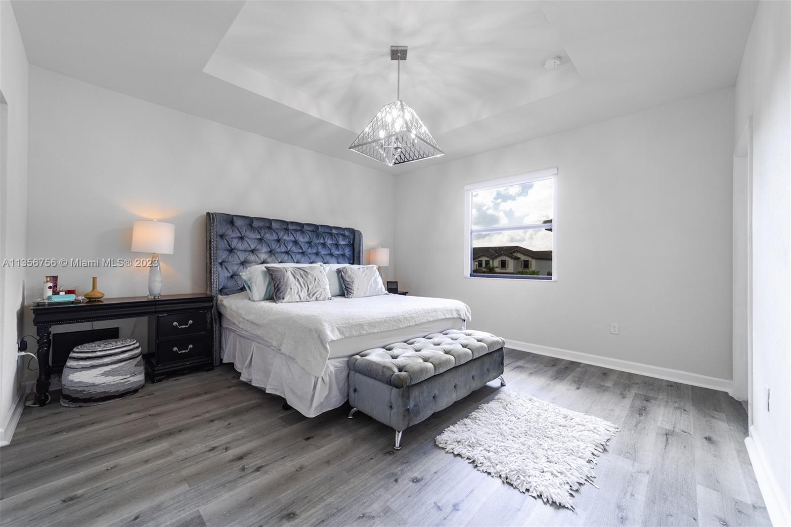11444 Southwest 251st Street Homestead, FL 33032 - Photo 23 of 40 a bedroom with a bed and a chandelier