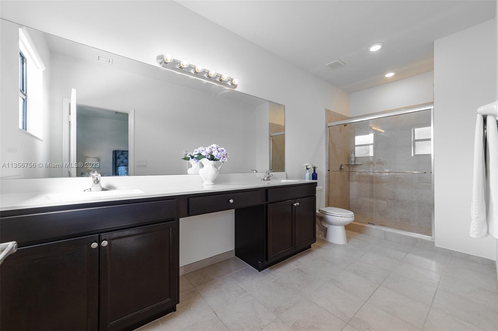 11444 Southwest 251st Street Homestead, FL 33032 - Photo 26 of 40 a bathroom with a double vanity sink a toilet and a mirror