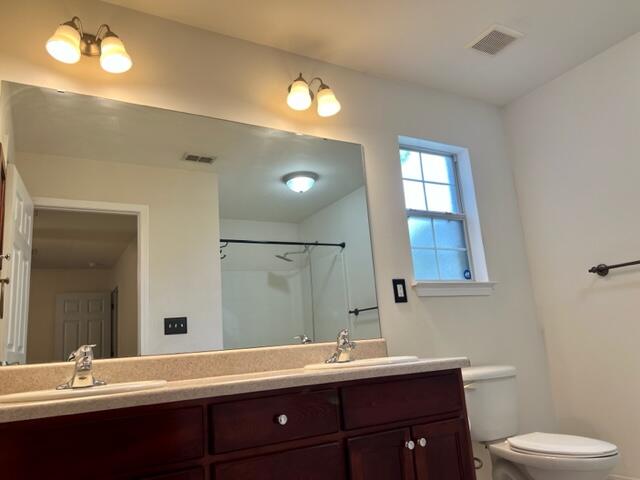 306 Shield Drive Crestview, FL 32539 - Photo 12 of 16 a bathroom with a double vanity sink toilet and a mirror