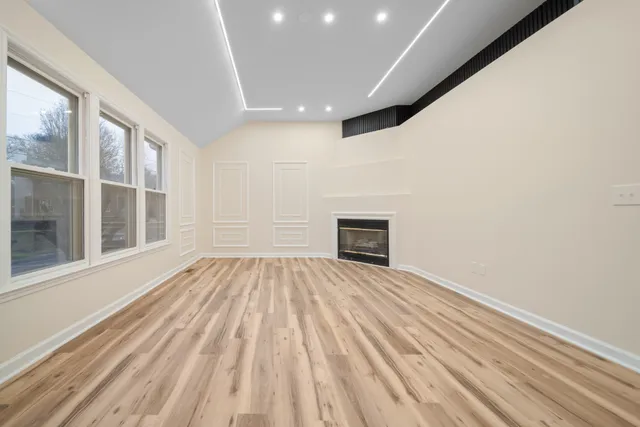 a view of empty room with wooden floor and fireplace