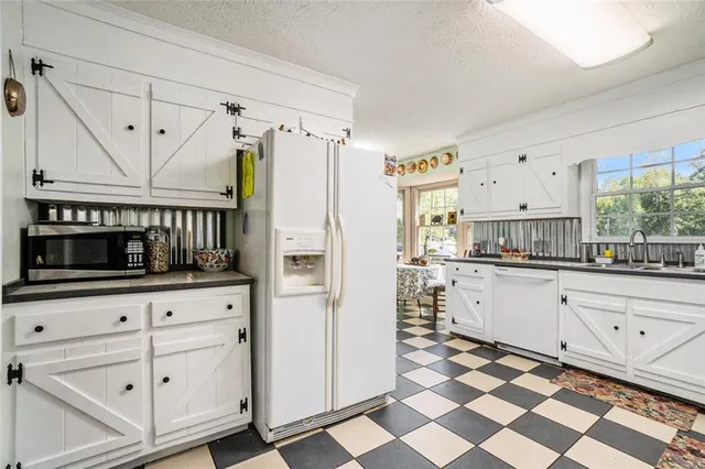 a kitchen with granite countertop white cabinets and appliances