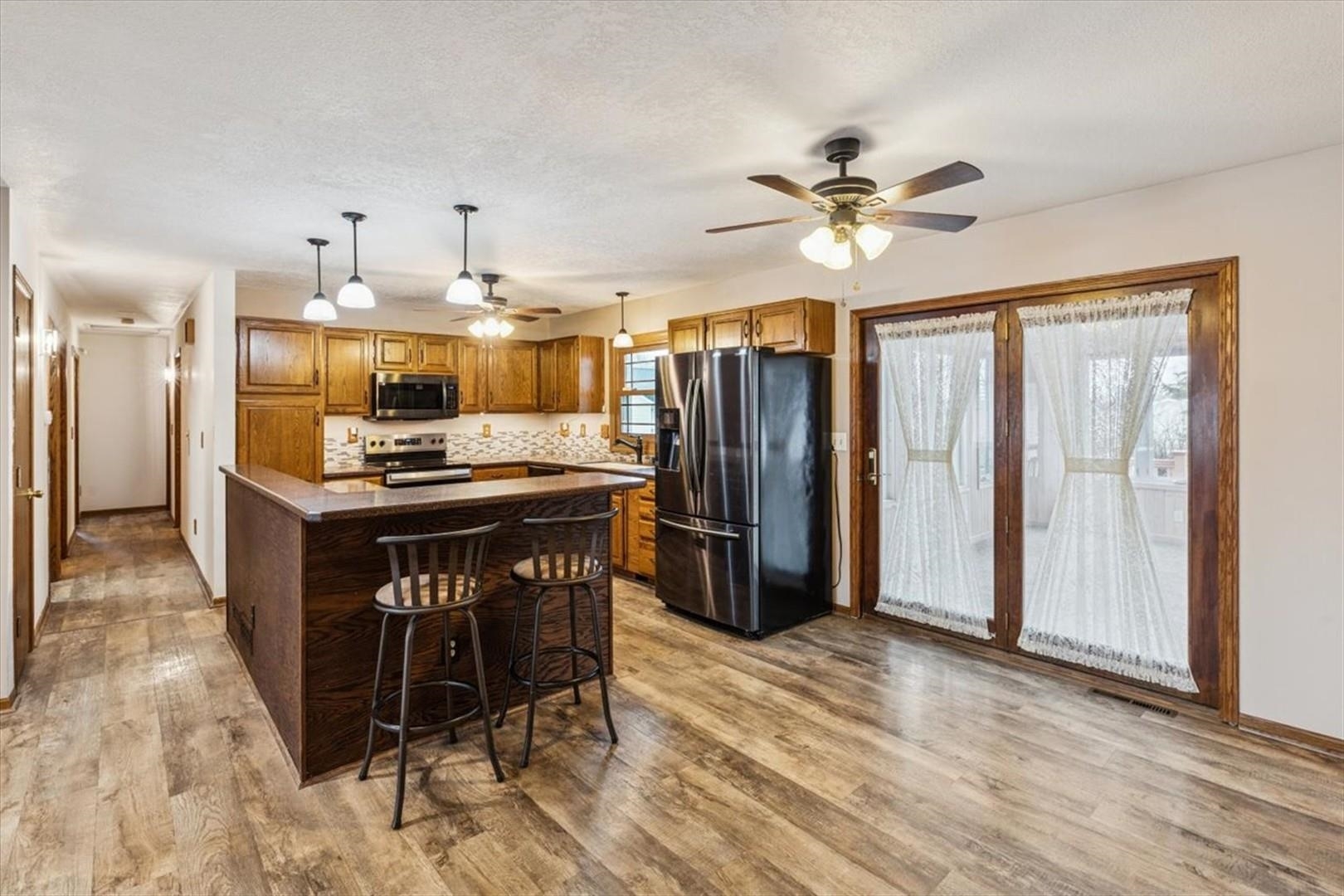 1045 Sweet Briar Lane Clinton, IA 52732 - Photo 11 of 33 a kitchen with stainless steel appliances kitchen island granite countertop a refrigerator a stove and a sink with granite countertops