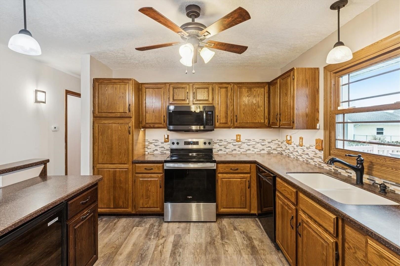 1045 Sweet Briar Lane Clinton, IA 52732 - Photo 12 of 33 a kitchen with stainless steel appliances granite countertop a sink stove and refrigerator