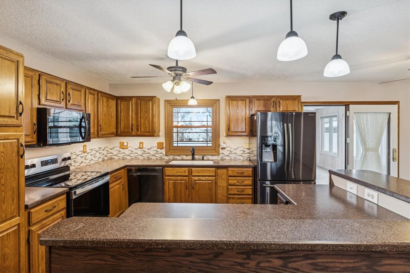 1045 Sweet Briar Lane Clinton, IA 52732 - Photo 13 of 33 a kitchen with stainless steel appliances granite countertop a sink refrigerator stove and microwave
