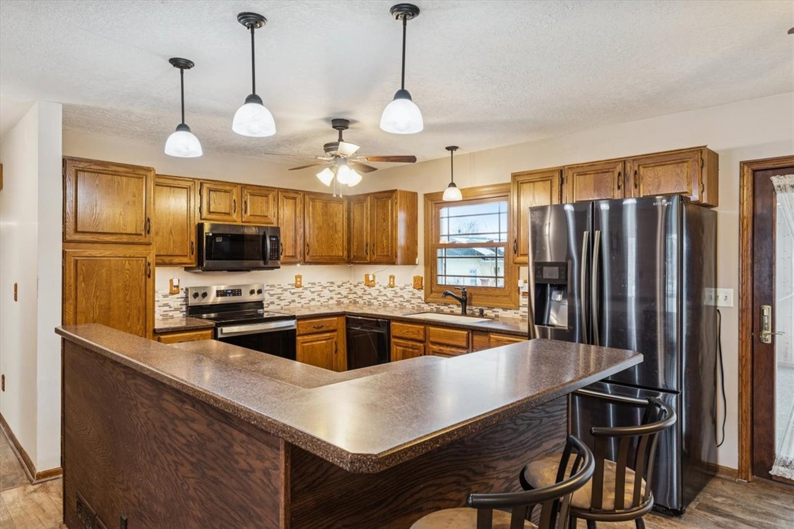 1045 Sweet Briar Lane Clinton, IA 52732 - Photo 10 of 33 a kitchen with cabinets a center island and stainless steel appliances